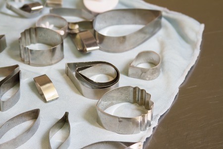 Many metal molds for cutting cookies of different shapes on a light background, close-up.の写真素材