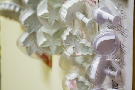 Many plastic molds for cutting cookies of different shapes on a light background, close-up.の写真素材