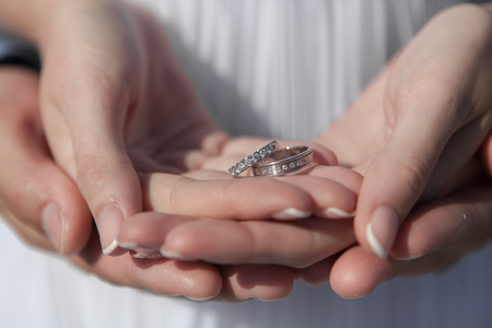 young couple honeymoon on the most romantic island Santorini, Greece, wedding rings in the palms.の写真素材