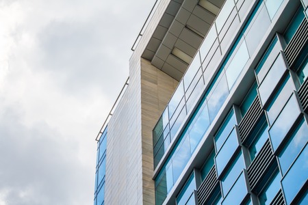 KHARKIV, UKRAINE - MAY 19, 2018: modern glass building skyscrapers with cloudy sky reflection....