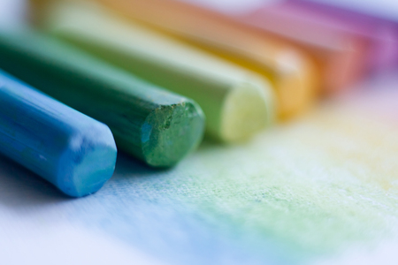 Extreme close-up of multicolored pastel chalks on a white surface, selective focusの写真素材