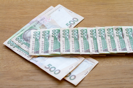 The arrow from the bills of the Ukrainian currency shows the direction in a small wallet, a business...