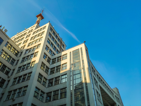 View up of State Industry Building or Gosprom built in Construction Art over blue sky, sun ray in...
