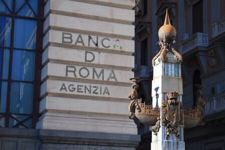 Naples, Italy - November 09, 2018: Close-up part of ship alto-relievo on a pole and a wall of a building with the name of a bank in Naples, Italyのeditorial素材