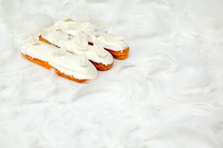 A set of three eclairs with white chocolate decor isolate on a white surface decorated with white...