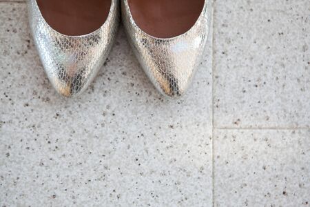 Closeup of the brides silver shoes toes on the marble floorの写真素材