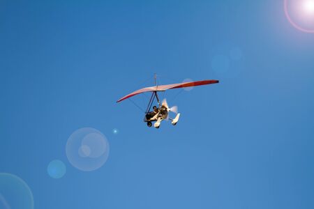 Kharkiv, Ukraine - July 09, 2016: A bottom view super lightweight hang glider or trike flies in clear blue skyのeditorial素材
