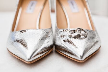 Closeup of the brides silver shoes toes and wedding rings on the marble floor, selective focusの写真素材