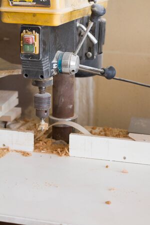 A boring machine with nozzle in the furniture workshop, selective focus