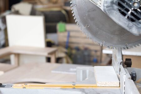 Closeup stationary circular saw on a carpentry table on a blurred background of a carpentry...