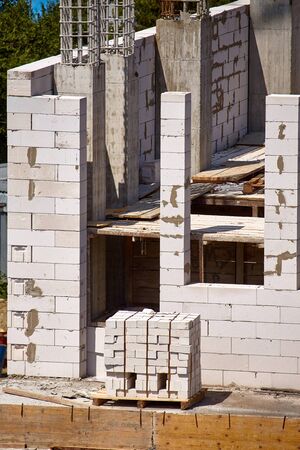Process of constructing the next floor of a high-rise building, cement supports and cinder block...