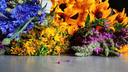 Closeup of a bouquet of wildflowers lies on a table, summer concept, rudbeckia, cornflower,...