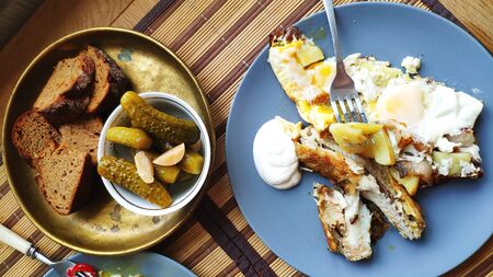 A top view breakfast dish, baked fish and potatoes with pickles, English breakfast, healthy eating concept, selective focusの写真素材