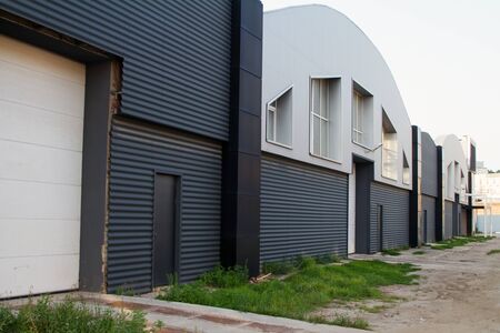 Gray industrial buildings of workshops or warehouses with lifting gates, doors and windows, copy spaceの写真素材