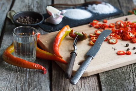 Close up of chopped hot chili peppers and heaps of salt, sugar, garlic, allspice, bay leaf on an old wooden surface, selective focusの写真素材