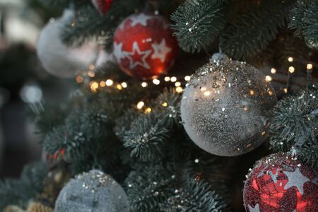 Close up white and red christmas balls with a golden garland on christmas tree branches, selective focusの写真素材