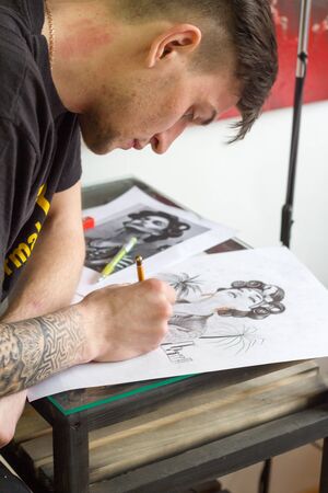 Kharkiv, Ukraine - April 08, 2017: Young professional tattoo artist draws a sketch of a future tattooのeditorial素材