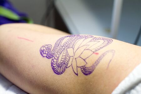 Kharkiv, Ukraine - April 08, 2017: Close-up drawing of a tattoo and lotus transferred to the client's hand to start the work of the tattoo masterのeditorial素材