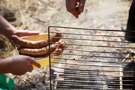 Grilled pork sausages cooked over campfire in a camp kitchen, selective focusの写真素材