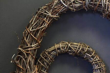 Detail close up Textured Christmas wreath made from woven vine branches, black candles and dry...