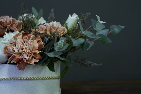 Box with a vintage bouquet on a dark background, selective focus