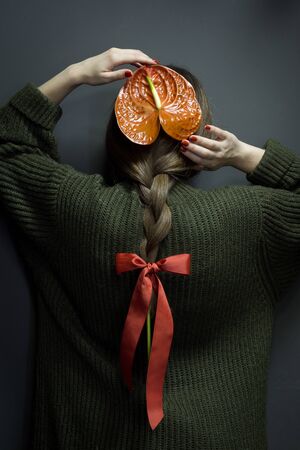 Rear view of girl with anthurium braided in hair, environmental protection concept, selective focusの写真素材