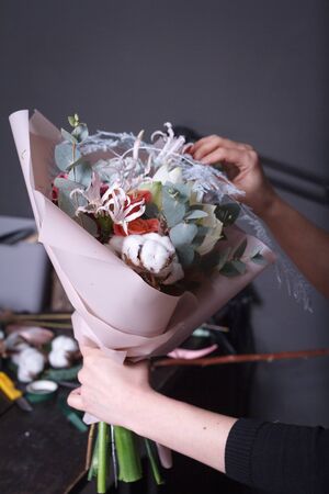 Woman florist makes bouquet to order, concept of own flower business, selective focusの写真素材
