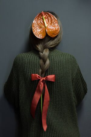 Rear view of girl with anthurium braided in hair, environmental protection concept, selective focusの写真素材