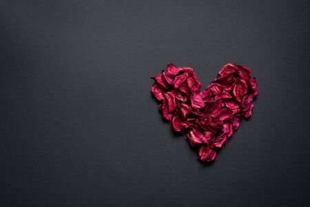Red petals formed in the shape of heart on a black background, congratulations conceptの写真素材