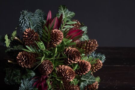 Winter bouquet of Nobilis fir twigs, cones, pistachio, leucodendron and ivy, winter gift conceptの写真素材