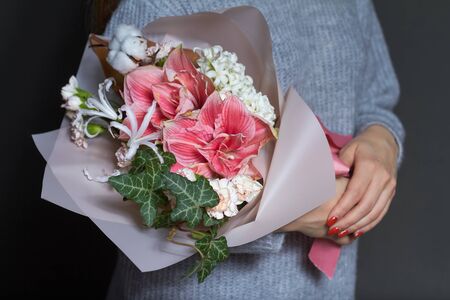 Girl holds in hands original bouquet in vintage style, greeting background or conceptの写真素材