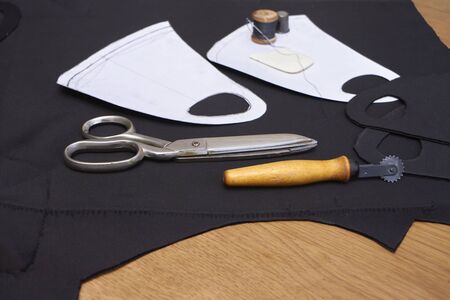 Process of making medical facial mask at home with sewing kit, black mask onwooden table, layout...