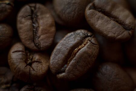 Extremely close up background roasted coffee beans with gold streaks, good morning concept