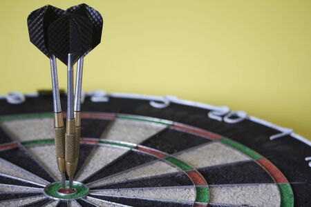 Three darts on bulls eye target of dartboard, concept of victory or goal achievement, selective...