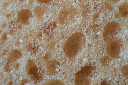 Abstract background yellow sponge for washing dishes closeup, selective focus