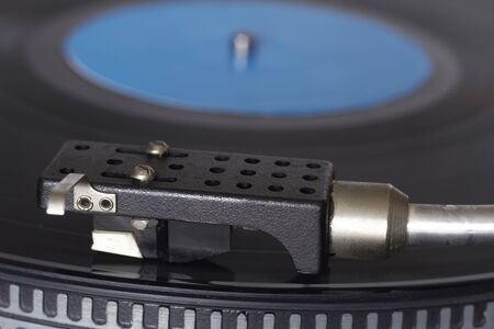 Extreme closeup of blue music record on turntable, turntable needle playing music, selective focus