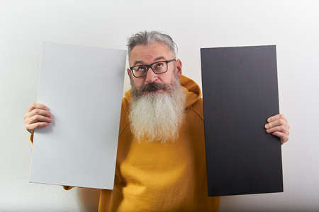 Portrait of mature gray-haired bearded man with white and black sheet over white background, selective focusの写真素材