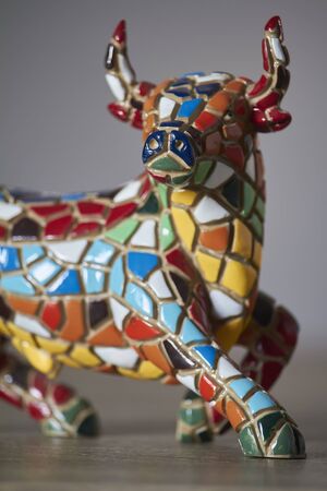 Miniature multicolored statue of bull in Gaudi style, traditional souvenir from Barcelona, it is not art object, only inexpensive spanish giftの写真素材