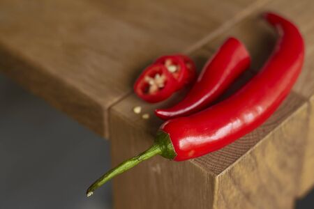Close up of sliced red hot chili peppers on wooden table, selective focusの写真素材