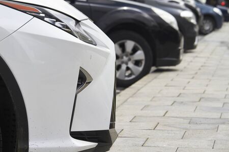 Lots of cars parked in public city parking, selective focus