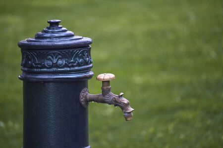 Closeup of old-style column with drinking water in public park, selective focusの写真素材