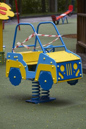 Empty playground without children with striped red and white warning tape, limitations quarantined for Covid19 coronavirusの写真素材