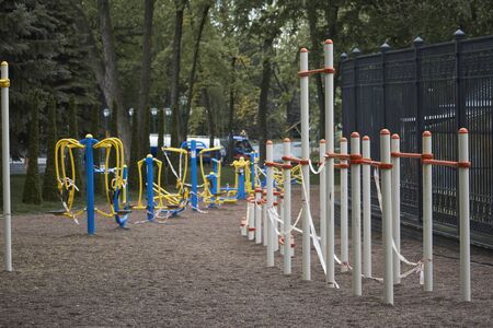 An empty outdoor fitness equipment wrapped with warning red and white tape during quarantine period of COVID-19の写真素材
