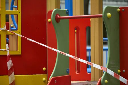 Empty playground without children with striped red and white warning tape, limitations quarantined for Covid19 coronavirusの写真素材