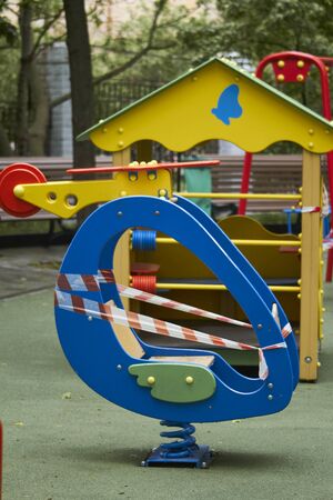 Empty playground without children with striped red and white warning tape, limitations quarantined for Covid19 coronavirusの写真素材