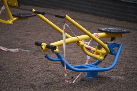 An empty outdoor fitness equipment wrapped with warning red and white tape during quarantine period of COVID-19の写真素材