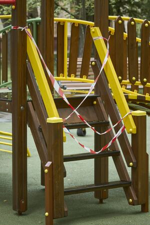 Empty playground without children with striped red and white warning tape, limitations quarantined for Covid19 coronavirusの写真素材