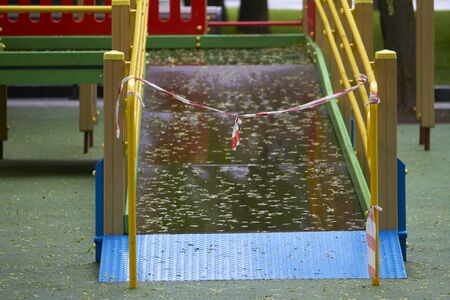 Empty playground without children with striped red and white warning tape, limitations quarantined for Covid19 coronavirusの写真素材