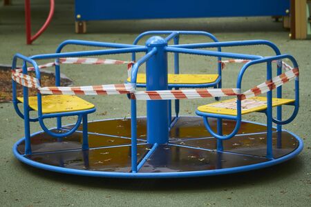 Empty playground without children with striped red and white warning tape, limitations quarantined for Covid19 coronavirusの写真素材