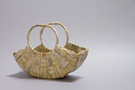 Empty straw wicker basket on a gray background. Natural decor of the interior, home. Natural eco materials, storage basketの写真素材